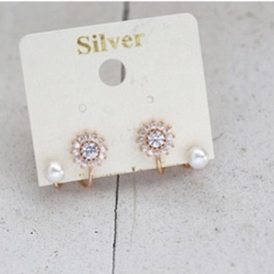 Boucles d'oreilles tournesol en or rose avec strass et perles sur carte argent
