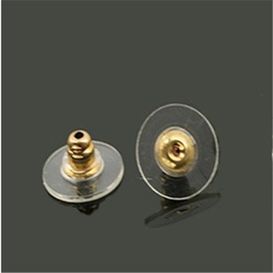 Macro shot of gold metal earring backs with transparent plastic safety disc pads