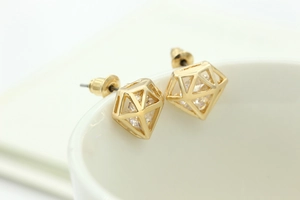 Détail de boucles d'oreilles géométriques creuses avec zircon clair en monture dorée
