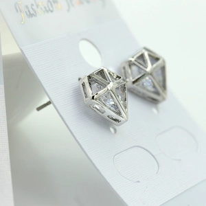 Détails macro des boucles d'oreilles géométriques argentées avec pierres en zircon clair