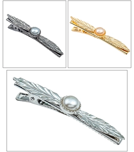 Detailed macro view of alloy feather hair clips with pearls in silver gold and gunmetal