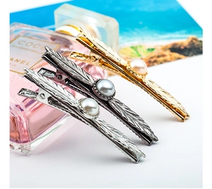 Detailed view of alloy feather hair clips in gold silver and black with pearls