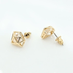 Gros plan de boucles d'oreilles dorées géométriques avec zircon et fermoir papillon