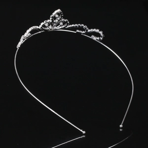 Detailed close-up of silver rhinestone crown headband with heart pattern and mirror reflection