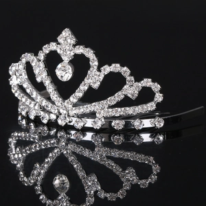 Corona di strass argento con cristallo a forma di cuore su superficie nera riflettente