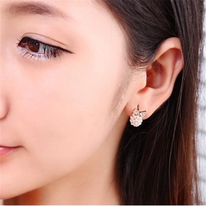 Elegant rose gold cat-shaped stud earrings with inlaid pearls on a model side view