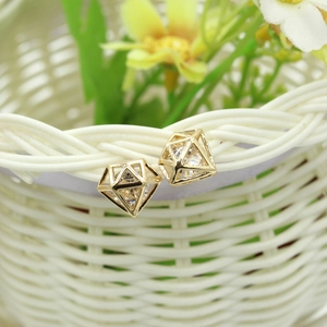 Gros plan sur des boucles d'oreilles géométriques dorées avec cristaux de zircon