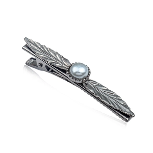 Vintage silver leaf hair clip with feather texture and a white pearl on a white background