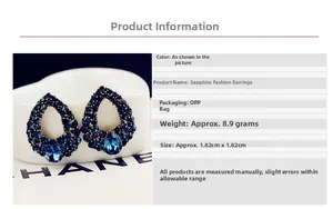 Detailed close-up of water drop shaped blue sapphire earrings with pavé diamond setting