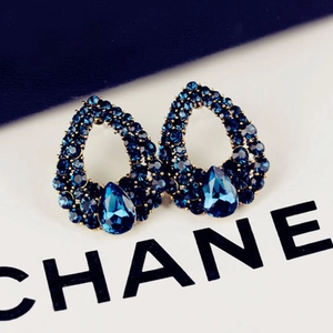 Elegant gold drop earrings with sapphire blue crystals in a vintage pear-shaped hollow design