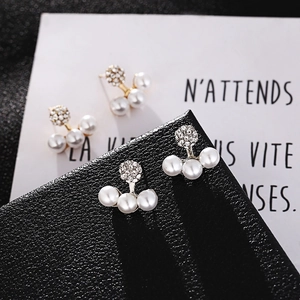 Elegant gold earrings featuring a sparkling crystal ball and three curved white pearls