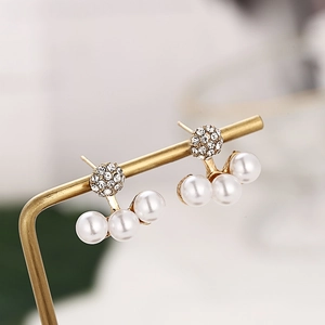Elegant gold earrings with sparkling pave crystals and three white pearls on a gold stand