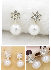 Macro detail of snowflake pearl earrings with crystal inlay and silver finish