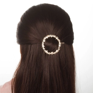 Detailed view of a gold star-shaped ring hair clip featuring small sparkling rhinestones