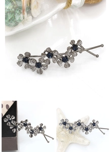 Detailed close-up of retro floral hair pin with dark blue crystals and antique silver finish