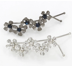 Close-up of metal flower hair clips with blue and clear crystal rhinestones