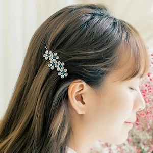 Elegant five-flower hair clip with blue crystals on woman's side profile hairstyle