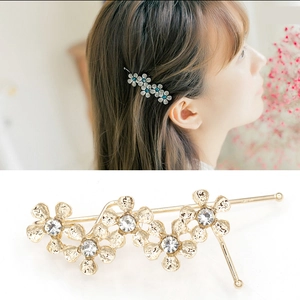 Elegant Korean style gold floral hair clip with crystals for women on a soft white background
