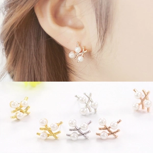 Détail de boucles d'oreilles perles en branche, finitions or, argent et or rose
