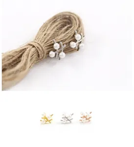 Détail des boucles d'oreilles branche de perles en finitions or, argent et or rose