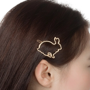 Nahaufnahme einer goldenen Hasen-Haarspange, die auf dunkelbraunem Haar natürlich gestylt ist