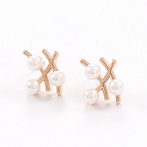 Boucles d'oreilles branche en or rose élégantes avec trois perles sur fond blanc