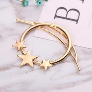 Barrette dorée minimaliste avec cercle et étoiles sur un fond en marbre élégant
