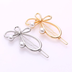 Close-up of hollow bow hair clips with pearls in gold and silver finish alloy