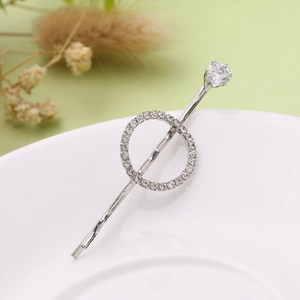 Eleganter silberner Haarclip mit funkelnden Strasssteinen und Zirkonkreis auf einem Teller