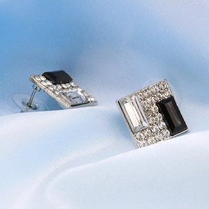 Macro detail of geometric black and white crystal stud earrings with silver metal backing