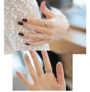 Close-up of minimalist crossover X ring and crystal butterfly open ring in gold and silver