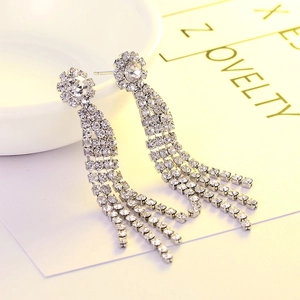 Boucles d'oreilles pendantes à pampilles en strass avec fleur sur présentoir blanc