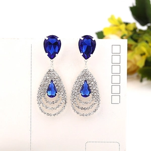 Détail de boucles d'oreilles saphir bleu en poire avec décoration de franges en cristal