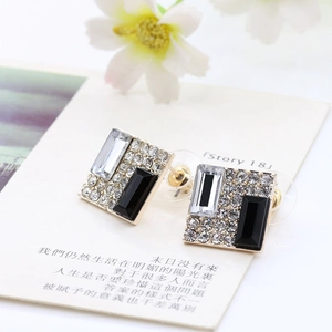 Close-up of geometric square studs with sparkling rhinestones and black and white crystals