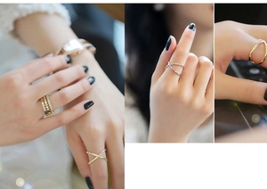 Detailed view of gold and silver layered rings with X-shape and rhinestone accents