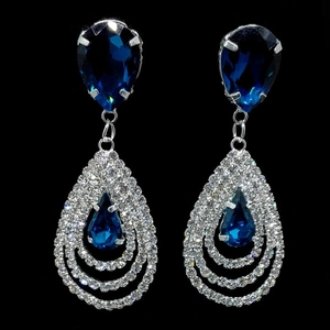 Vue détaillée des boucles d'oreilles goutte avec pierres bleu foncé et cadre en cristal