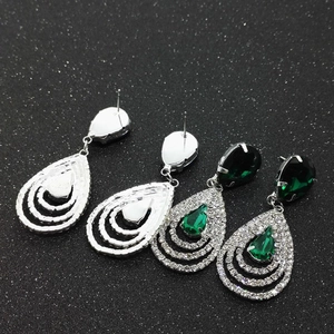 Détails de l'avant et de l'arrière de boucles d'oreilles poires en cristal vert et métal