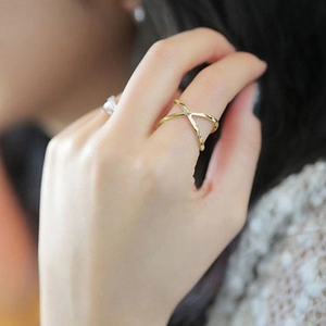 Minimalist gold-tone X-shaped hollow crossover ring shown on the index finger
