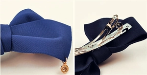 Vue détaillée du nœud en tissu bleu marine avec pendentif doré et pince à ressort métal