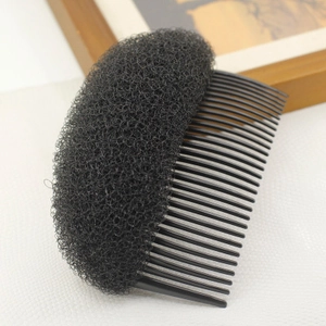 Close-up of a black hair styling tool featuring a plastic comb and volumizing sponge pad