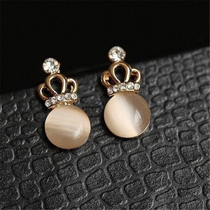 Macro detail of gold crown stud earrings featuring cat eye stone and tiny zircon crystals