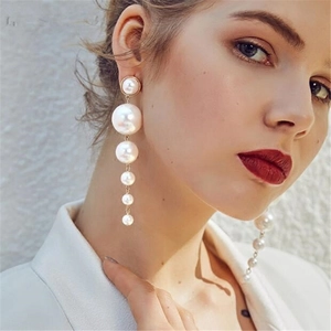 Boucles d'oreilles longues tendance avec cinq perles crème dégradées sur mannequin