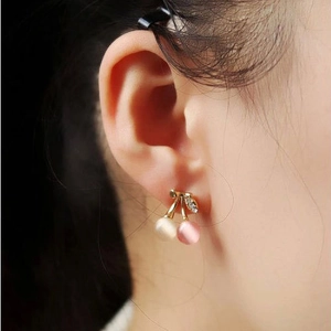 Détail des boucles d'oreilles cerises avec pierres œil de chat et feuilles en cristal