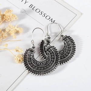 Détail de boucles d'oreilles bohèmes en argent vieilli avec motifs filigranes complexes