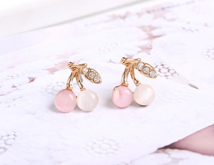 Détail de boucles d'oreilles cerises avec plaquage or rose et strass scintillants