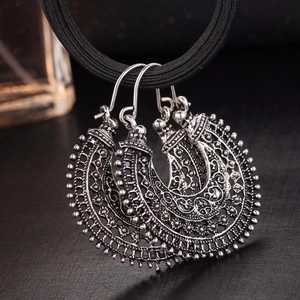 Gros plan détaillé des boucles d'oreilles bohèmes en croissant argent antique ciselé