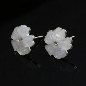 Detail view of five-petal flower stud earrings with sparkling resin and silver tone pins