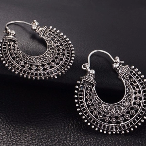 Boucles d'oreilles créoles vintage argentées avec détails filigranes sur cuir noir