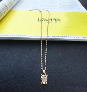 Detailansicht der Katzen-Halskette mit Opal-Stein und Perle an goldener Kette