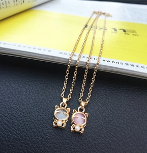 Detailaufnahme der Katzen-Halskette in Gold mit Katzenaugenstein und kleiner weißer Perle